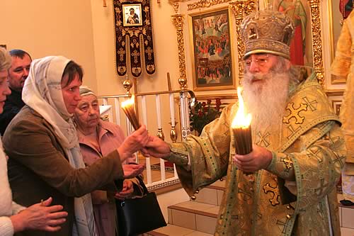 Митрополит Владимир раздает зажженные свечи народу